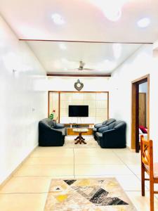 a living room with two couches and a television at i7 HOMESTAY in Jāmb