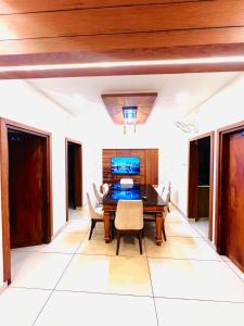 a dining room with a wooden table and chairs at i7 HOMESTAY in Jāmb