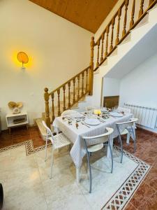 a dining room with a white table and chairs at El Rincón de la Mimosa in Vega de Espinareda