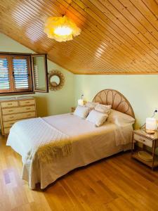 a bedroom with a large bed and a wooden ceiling at El Rincón de la Mimosa in Vega de Espinareda