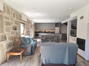 ein Wohnzimmer mit Sofa und Tisch in der Unterkunft Casa Vilarinha Gerês in Taboabela