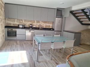 eine Küche mit einem blauen Tisch und Stühlen in der Unterkunft Casa Vilarinha Gerês in Taboabela