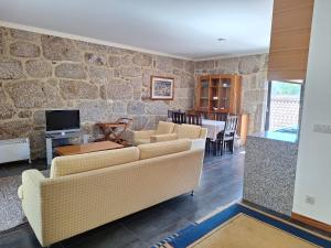 ein Wohnzimmer mit zwei Sofas und einem Fernseher in der Unterkunft Casa Feixa Gerês in Lordelo