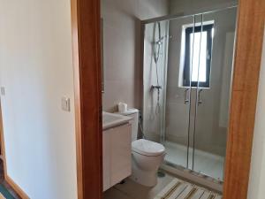 ein Badezimmer mit Toilette und Glasdusche in der Unterkunft Casa Feixa Gerês in Lordelo