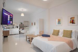 a white bedroom with a large bed and a kitchen at Luma Boutique Collection by PH in San Juan