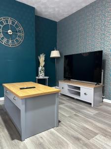 a living room with a tv and a clock on the wall at Delux Double Bedroom in Hackington