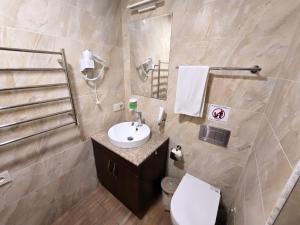 エレバンにあるYour Yerevan Homeの白い洗面台とトイレのあるバスルーム +11枚の写真
