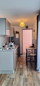 a kitchen with a sink and a table with a pink screen at Bungalow tiayo in Saint-Leu +23 photos