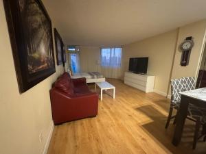 Spacious Apt Ocean Reserve Resort Amenities في صني آيلز بيتش: غرفة معيشة فيها كرسي احمر وتلفزيون