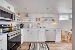 Una cocina con gabinetes blancos y un fregadero. en Stay Portland - Vibrant Portland Getaway, Chic Flat, en Portland