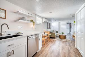 cocina con armarios blancos y comedor en Stay Portland - Vibrant Portland Getaway, Chic Flat, en Portland