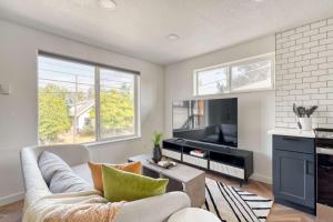 Stay Portland - The Perfect Artist's Retreat in Woodstock في بورتلاند: غرفة معيشة مع أريكة وتلفزيون