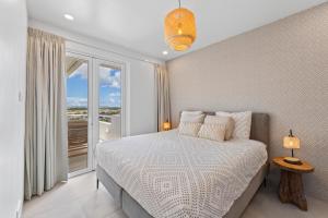 une chambre avec un lit et une grande fenêtre dans l'établissement Blue Bay- Penthouse 4 persons Aquamarine, à Blue Bay 21 autres photos