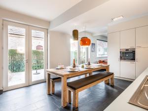 a kitchen with a wooden table and a bench at La Terrasse in Sint-Idesbald