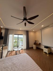 a bedroom with a ceiling fan and a flat screen tv at JonHouse in Phu Quoc