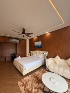 a bedroom with a large bed and a couch at JonHouse in Phu Quoc