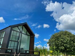 a house with glass windows and a blue sky at Lalaland CD in Ban Mae Khon