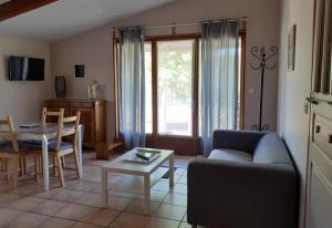a living room with a couch and a table at Gîte Pic de Cluzel in Saurier