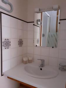 a white bathroom with a sink and a mirror at Gîte Pic de Cluzel in Saurier
