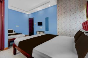a bedroom with a white bed and a blue wall at Hotel O Redmoon Chikkamagaluru Railway Station in Chikmagalūr