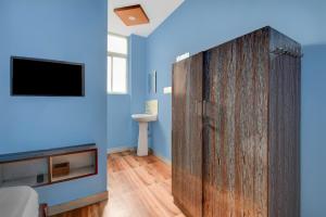 a room with a large wooden cabinet with a television at Hotel O Redmoon Chikkamagaluru Railway Station in Chikmagalūr +21 photos