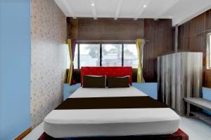 a bedroom with a large bed in a room at Hotel O Redmoon Chikkamagaluru Railway Station in Chikmagalūr