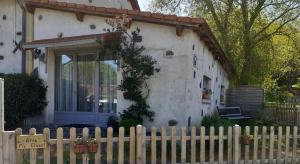 a white house with a fence in front of it at Gîte Pic de Cluzel in Saurier