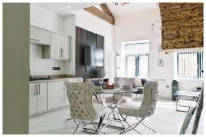 a kitchen and dining room with a table and chairs at 1Bed Apt- Sleeps 6 City Center Jacuzzi Bath Wifi in Bradford