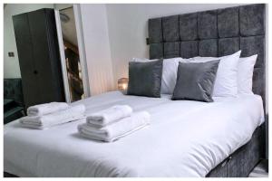 a large white bed with towels on top of it at 1Bed Apt- Sleeps 6 City Center Jacuzzi Bath Wifi in Bradford