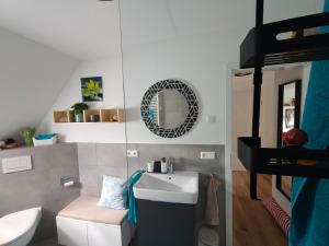 Un baño con lavabo, inodoro y espejo. en Onkel Franz, en Ohlsbach 43 fotos más