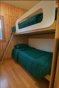 ペーイオ・フォンティにあるCasa Fioccoの緑のシーツが備わる小さな部屋の二段ベッド2台