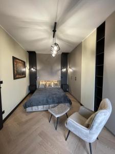 a bedroom with a bed and a table and a chair at Ludowa Apartment in Skorka +5 photos