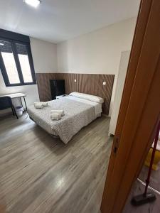 a bedroom with a bed with two towels on it at Coliving Leon in León