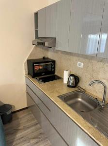 une cuisine avec un évier et un micro-ondes dans l'établissement Domina Coral Bay Resort Elisir, à Charm el-Cheikh