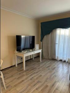 - un salon avec une télévision et une table avec une télévision dans l'établissement Domina Coral Bay Resort Elisir, à Charm el-Cheikh