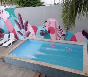 a swimming pool in front of a wall with a mural at Bm-14G Charming Cartagena Lodge with Shared Pool and Private Terrace in Cartagena de Indias