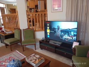 a living room with a flat screen tv and chairs at CasaMamma in Drama