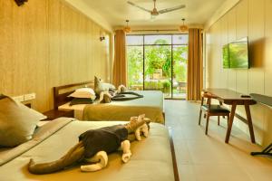 a bedroom with two beds with a stuffed animal on the couch at Ahola Thoddoo, Maldives in Thoddoo