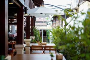 an outdoor patio with tables and chairs and plants at Sarana Guest House in Luang Prabang +30 photos