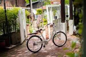 a bike parked next to a white fence at Sarana Guest House in Luang Prabang