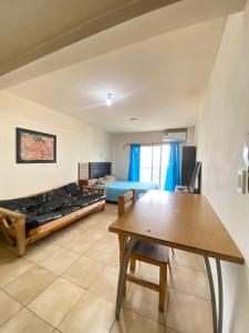 a living room with a bed and a table at monoambiente zona pellegrini in La Porteña