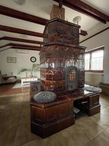a living room with a large wood stove in a room at Magyar Lovasvendégház in Szilvásvárad