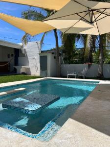 - Piscina con sombrilla y mesa en BuenaMar Malibu Beach, en Sonsonate
