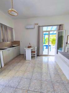 a large room with a kitchen and a table at Venetos Studios in Livadi Astypalaias