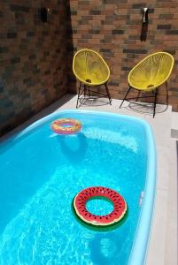 a pool with two chairs and a inflatable at Casa Amarela da Prainha de Mambucaba - Piscina aquecida in Paraty