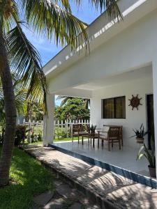 Un patio de una casa con una mesa y sillas. en BuenaMar Malibu Beach, en Sonsonate