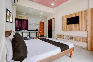 Una televisión o centro de entretenimiento en Hotel O Saptashrungi Lodging