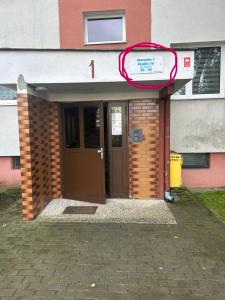 a front door of a building with a sign above it at Włocławek Norwida in Włocławek