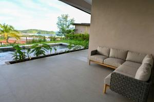 a living room with a couch and a view of a pool at Hillside Oceanview Home with Pool in Venao in Playa Venao