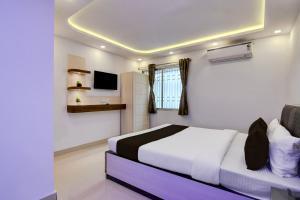 a bedroom with a bed and a tv in it at Hotel O Acroview in Ballygunge